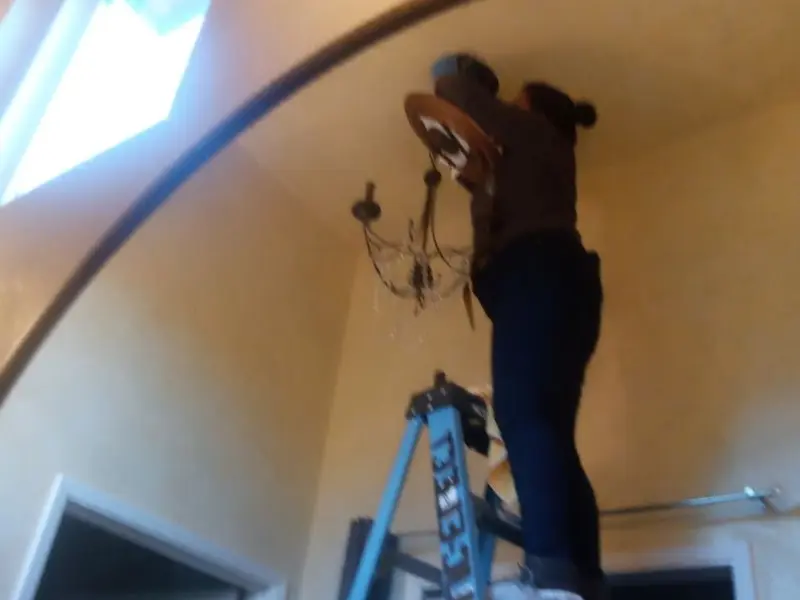 Electrician installing a chandelier in a Tarboro residence